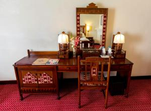 a desk with a chair and a mirror in a room at Swat Serena Hotel in Saidu