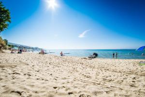 eine Gruppe von Menschen an einem Strand mit Blick auf das Meer in der Unterkunft Premier Fort Beach Resort in Sonnenstrand