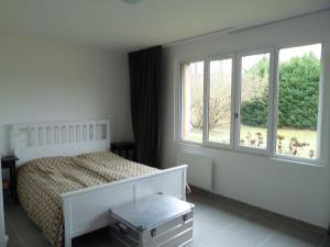 a bedroom with a bed and a large window at Longère en Sologne 2 in La Boullaye