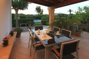 eine Terrasse mit einem Tisch und Stühlen auf einer Terrasse in der Unterkunft Roig Miquel house just 10m driving from Pollensa in Pollença