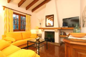 ein Wohnzimmer mit einem gelben Sofa und einem Kamin in der Unterkunft Roig Miquel house just 10m driving from Pollensa in Pollença