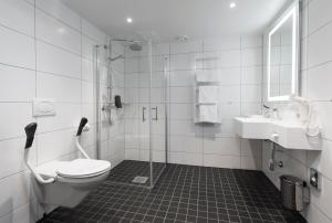 
a bathroom with a toilet, sink, and shower at Thon Hotel Rosenkrantz Oslo in Oslo
