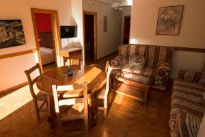 un salon avec une table et un canapé dans l'établissement Apartamentos Las Palmeras, à Cangas de Onís