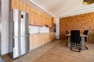 a kitchen with a stainless steel refrigerator and a table at Apartament Loft in Augustów