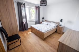 sypialnia z łóżkiem, biurkiem i oknem w obiekcie Apartament Loft w mieście Augustów