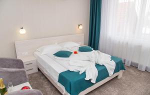 1 dormitorio con 1 cama con toallas en Pensiunea Amso, en Sibiu