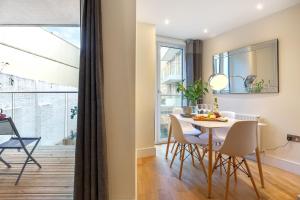 a kitchen and dining room with a table and chairs at Two Bedroom Apartments in Limehouse in London