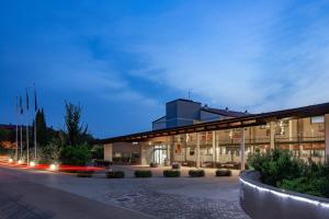 un bâtiment de nuit avec une route devant lui dans l'établissement Parc Hotel, à Peschiera del Garda