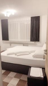 a bedroom with a large bed with white sheets at Hotel-Restaurant Haus Nattkemper in Hamm