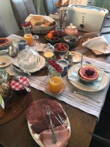 una mesa de madera con platos de comida. en B&B De Koraal en Emmen