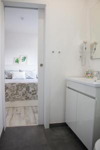 a white bathroom with a sink and a toilet at Casa d'Avó in Porto