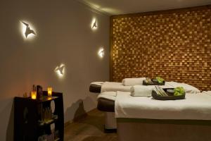two beds in a room with lights on the wall at The Residence Porto Mare - PortoBay in Funchal +42 photos