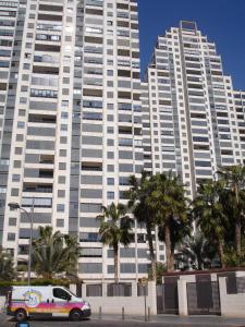 a white van parked in front of two tall buildings at Gemelos 26 - Zand Properties in Benidorm
