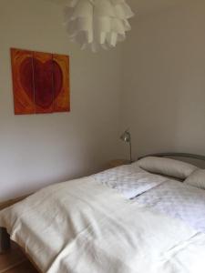RosengartenにあるTop Appartement 2 in Rosengarten/Hamburgの白いベッドが備わる壁画のあるベッドルームです。