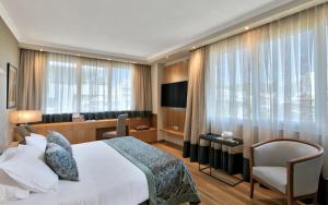 a hotel room with a bed and a television at Divani Caravel in Athens