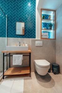 La salle de bains est pourvue de toilettes blanches et d'un lavabo. dans l'établissement Miha Luxury Apartment, à Belgrade