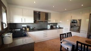 a kitchen with white cabinets and a table with chairs at Global Immo 8005 Casa Muga in Pau