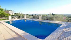 een zwembad met blauw water in een tuin bij Global Immo 8005 Casa Muga in Pau