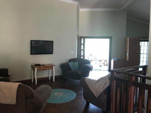 a living room with a couch and a chair and a television at Komati Kruger Villas in Komatipoort