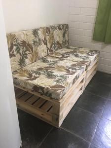 a couch sitting on a wooden pallet in a room at Apartamento em Condomínio Praia de Boiçucanga Litoral Norte in Boicucanga