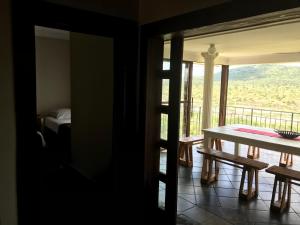 a room with a table and a balcony with a bed at Komati Kruger Villas in Komatipoort