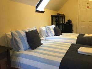 a room with two beds with blue and white pillows at Darroch View B&B in Invermoriston