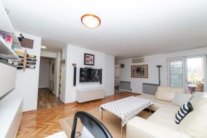 uma sala de estar com um sofá branco e uma mesa em Mario Apartment em Budva