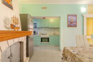 a kitchen with green cabinets and a counter top at Vila petra in Prizba