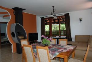 a living room with a dining room table with a fireplace at Vidima Apartment Hotel in Apriltsi