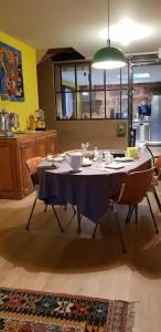 a dining room table with a blue tablecloth and chairs at Natangora in Marcillac-Vallon