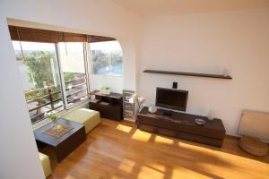 a living room with a large window and a television at Argola Kraljevica apartment in Kraljevica