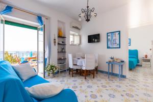 un soggiorno con divano blu e tavolo di Isabella Massalubrense a Massa Lubrense