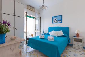 a blue bed in a room with a window at Isabella Massalubrense in Massa Lubrense