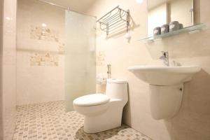 une salle de bain blanche avec toilettes et lavabo dans l'établissement 蘑菇村一津宿囍民宿, à Taïtung 17 autres photos