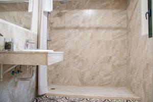 a bathroom with a sink and a shower at Hostal Boutique Casa La Laja in Chiclana de la Frontera