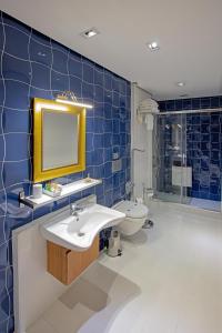 ein blau gefliestes Badezimmer mit Waschbecken und Toilette in der Unterkunft Nowy Efendi Hotel - Special Category in Istanbul + 64 Fotos