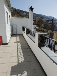balcón de una casa blanca con vistas en Apartamento Ruta de las Nieves, en Capileira