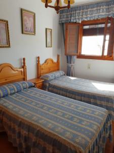 カピレイラにあるApartamento Ruta de las Nievesのベッドルーム1室(ベッド2台、窓付)
