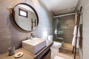 a bathroom with a sink and a mirror and a toilet at Casa Amarela in Fernando de Noronha