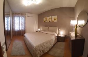 a bedroom with a bed and two lamps and a window at Appartamento New in Castellammare del Golfo