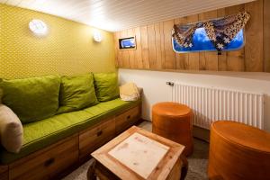 a living room with a green couch and a table at Bateau péniche au coeur de Lille in Lille