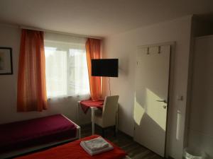 Altenberg的住宿－Gasthaus Schwarzer Adler，一间卧室配有一张床、一个窗口和一张书桌