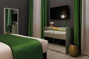een slaapkamer met een bed met groene gordijnen en een tv bij San Lio Tourist House in Venetië