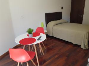 a room with a table and two chairs and a bed at Laprida 519 in Rosario