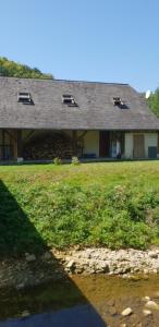 a house with windows and a grass field at Maison du bonheur in Gan