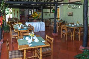 een restaurant met houten tafels en stoelen met bloemen erop bij Hotel Campestre Los Arrayanes in Moniquirá