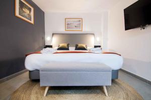 a hotel room with a large bed with a ottoman at Welcomer Apartments Valencia in Valencia
