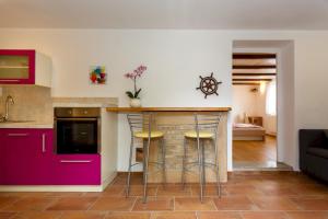 uma cozinha com armários roxos e um balcão com bancos em Villa Dora em Bajčići