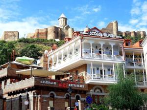 a large brick building with a balcony overlooking a city at Hotel Aivani Old Tbilisi in Tbilisi City