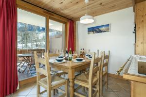 een eetkamer met een houten tafel en stoelen bij APARTMENT KANDAHAR - Alpes Travel - Central Chamonix - Sleeps 4 in Les Houches